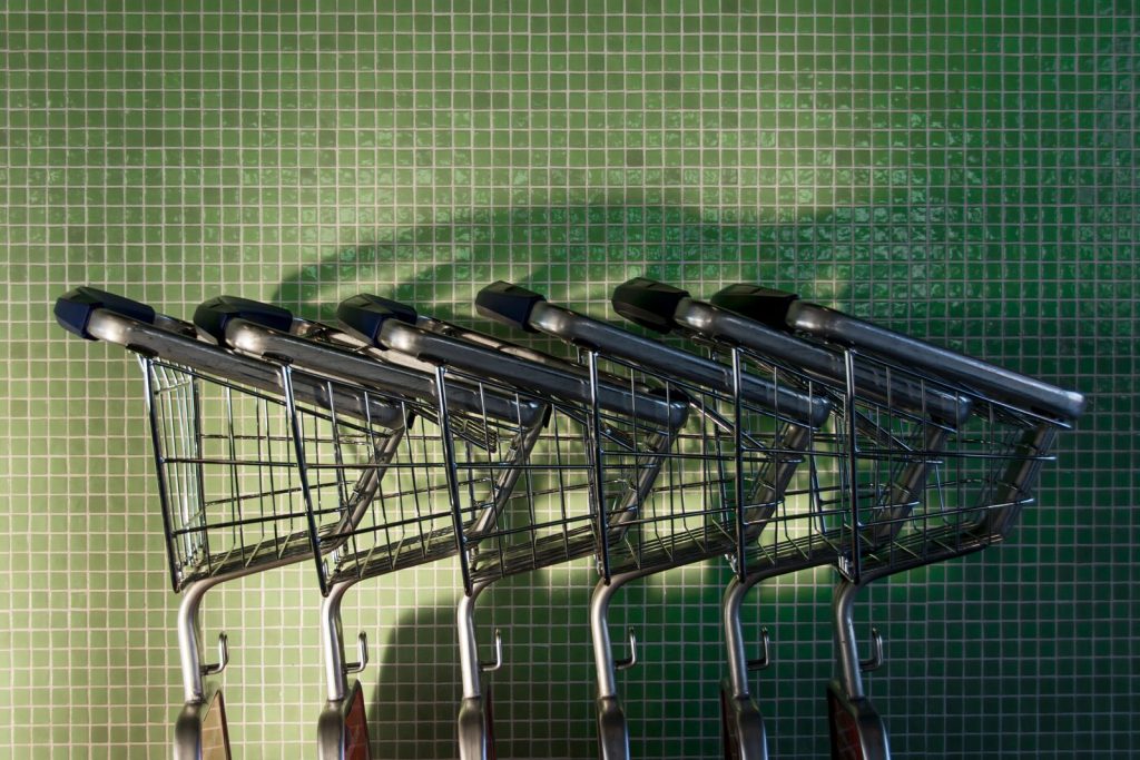 Winkelkarren tegen een groene tegelmuur